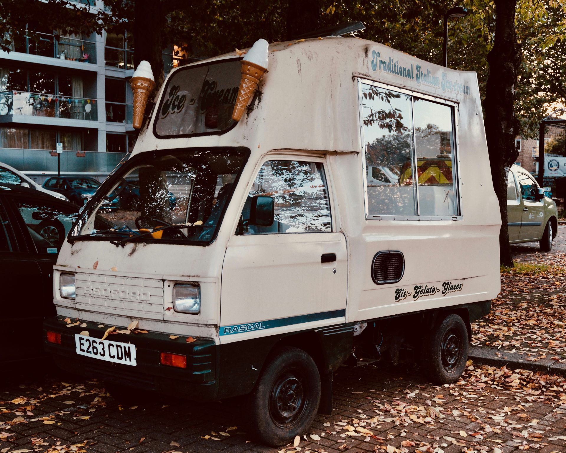 A small white truck parked next to a black car